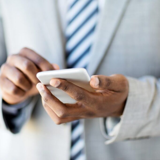 closeup african man using cell phone in office